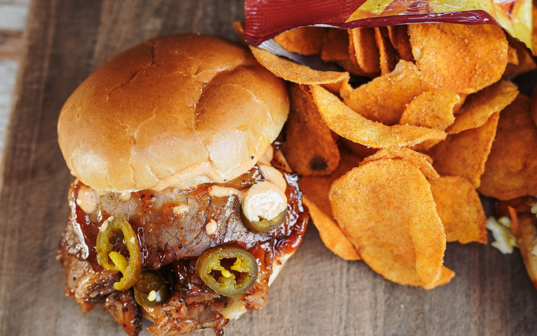 A Southern Luv BBQ sandwich with jalapeños and house-made barbecue chips